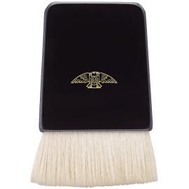 A black flat makeup brush with short light-colored bristles and a small gold emblem on the handle.