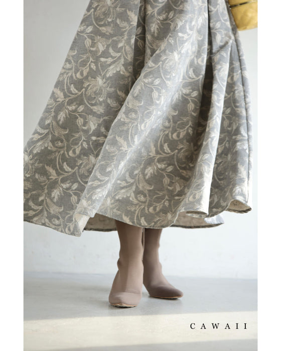 Lower half of a floral jacquard midi skirt worn by a model, showing the hem and shoes.