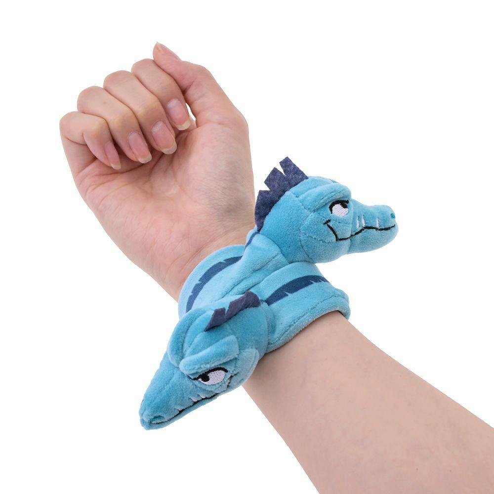 A blue Flotsam & Jetsam plush decorative hairband wrapped around a wrist.