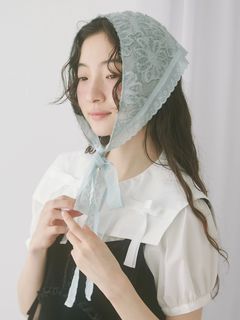Model wearing the flower jacquard headdress tied under her chin.