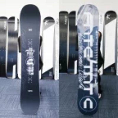 Front and back views of a TNTC snowboard standing upright against a wall.