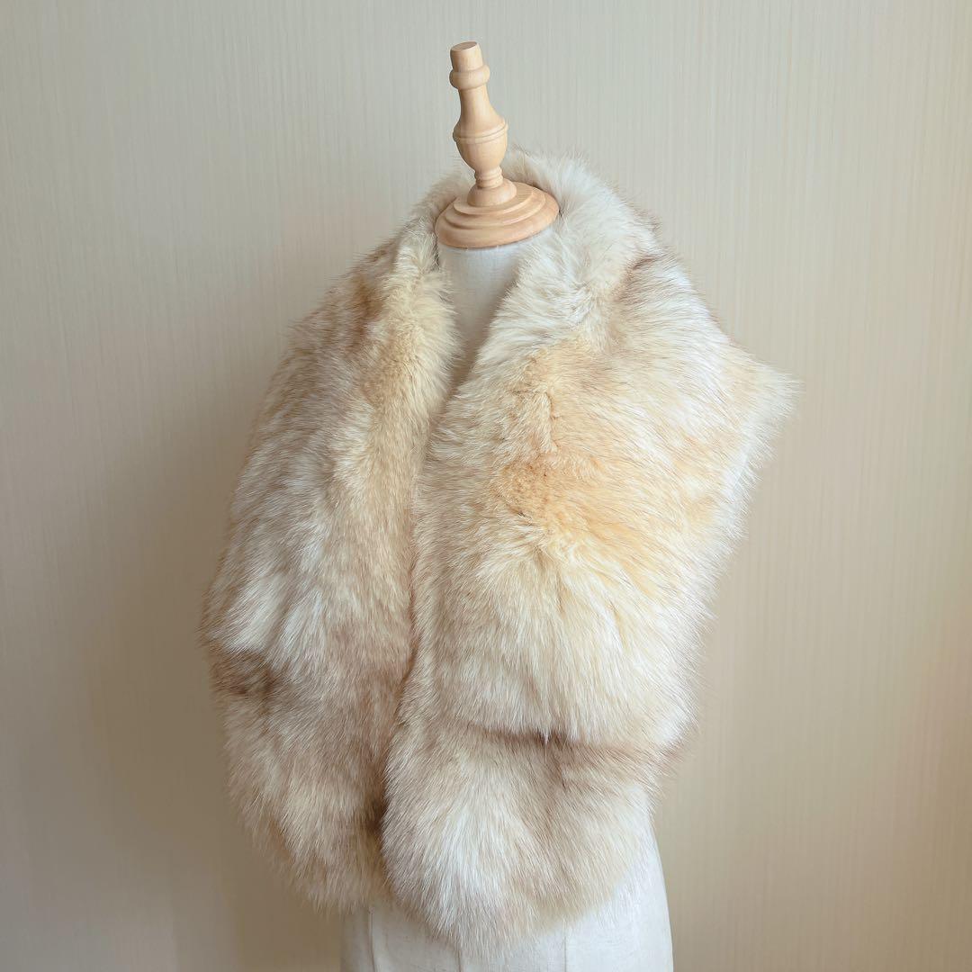 Ivory-beige fox fur muffler draped on a dress form against a plain background.