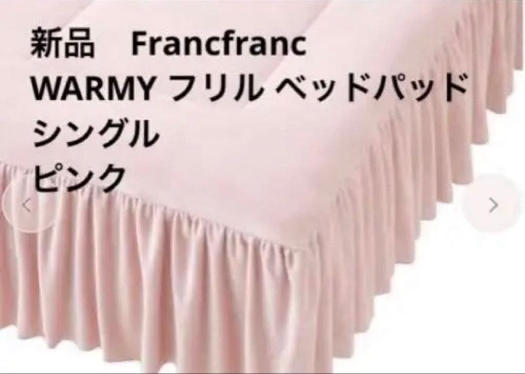 Pink frilled bed pad with a gathered ruffled skirt shown covering a single bed.