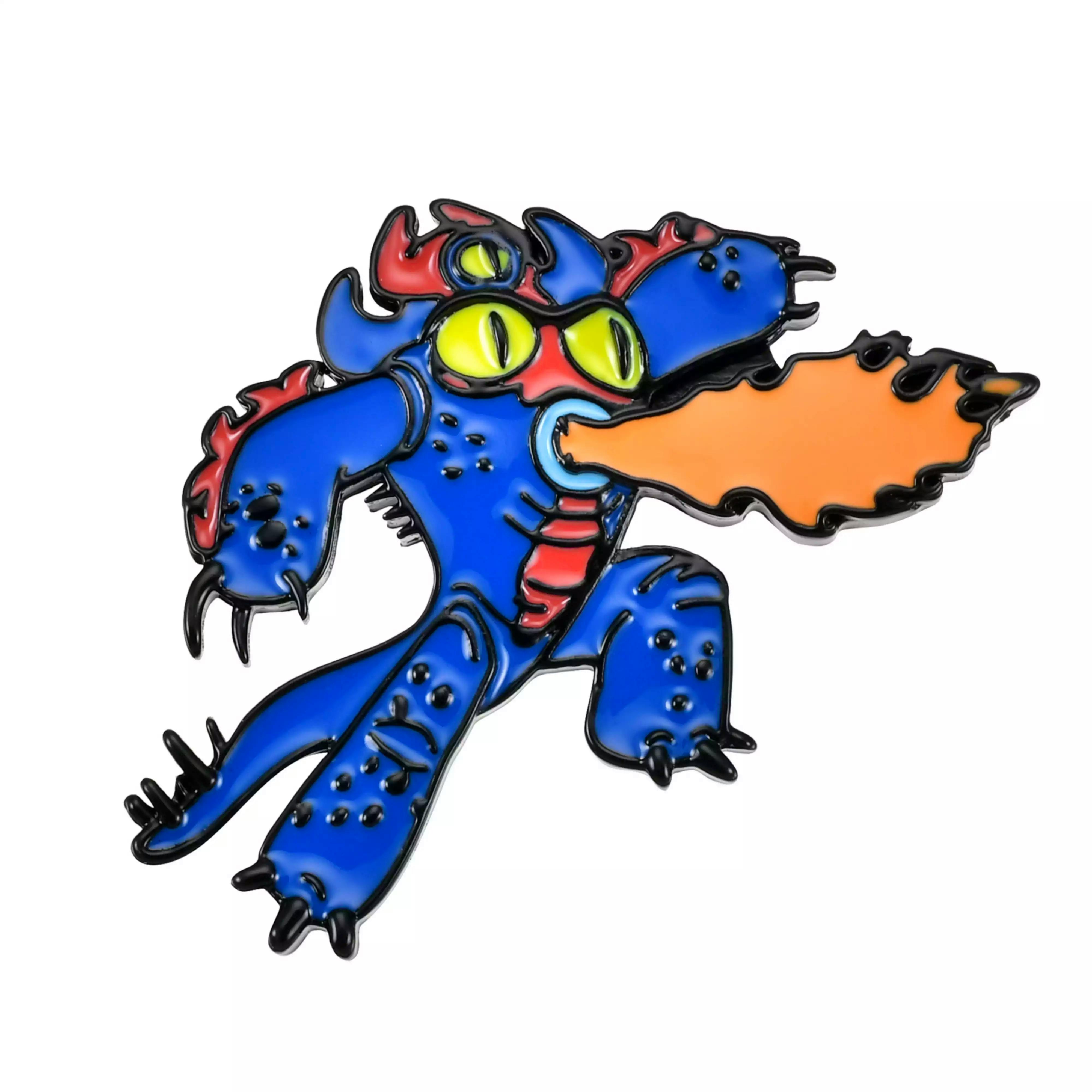 Close-up photograph of a blue Fred enamel pin badge from Big Hero 6 showing him breathing an orange flame.