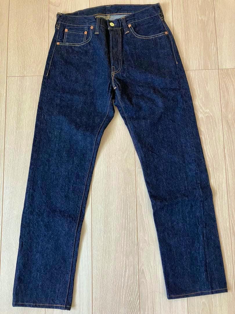 Front view of the freewheelers 661XX 1956 model men's jeans laid flat on a wooden floor.