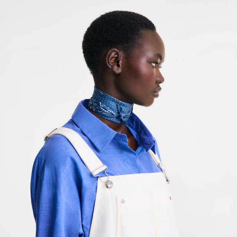 Model in profile wearing the blue French Bandana silk scarf tied around her neck.