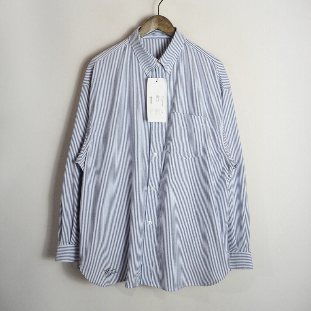 Striped long-sleeve men’s button-up shirt hanging on a wooden hanger with a tag attached.