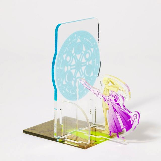 An assembled acrylic 『葬送のフリーレン』 book stand featuring a round decorative panel and a character acrylic piece on a white background.