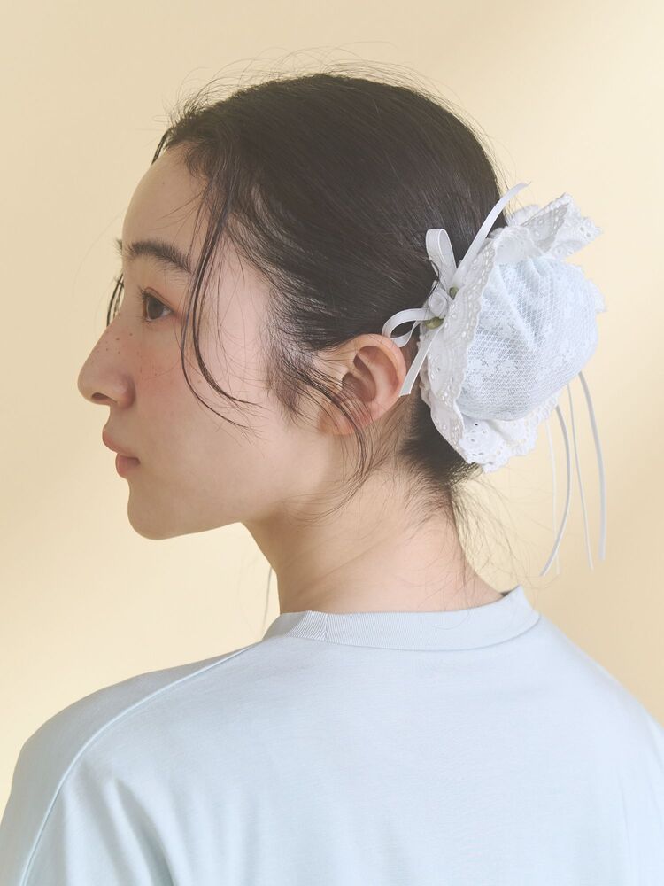 Side view of a model wearing the white frill soft chignon cap (hair scrunchie).