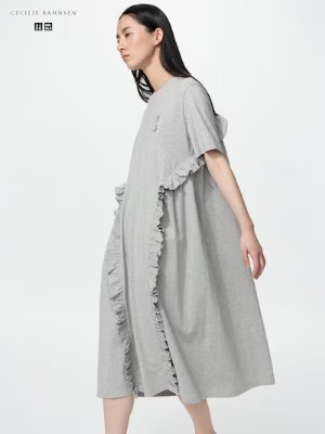 Side view of a woman modeling a grey cotton frill T dress.