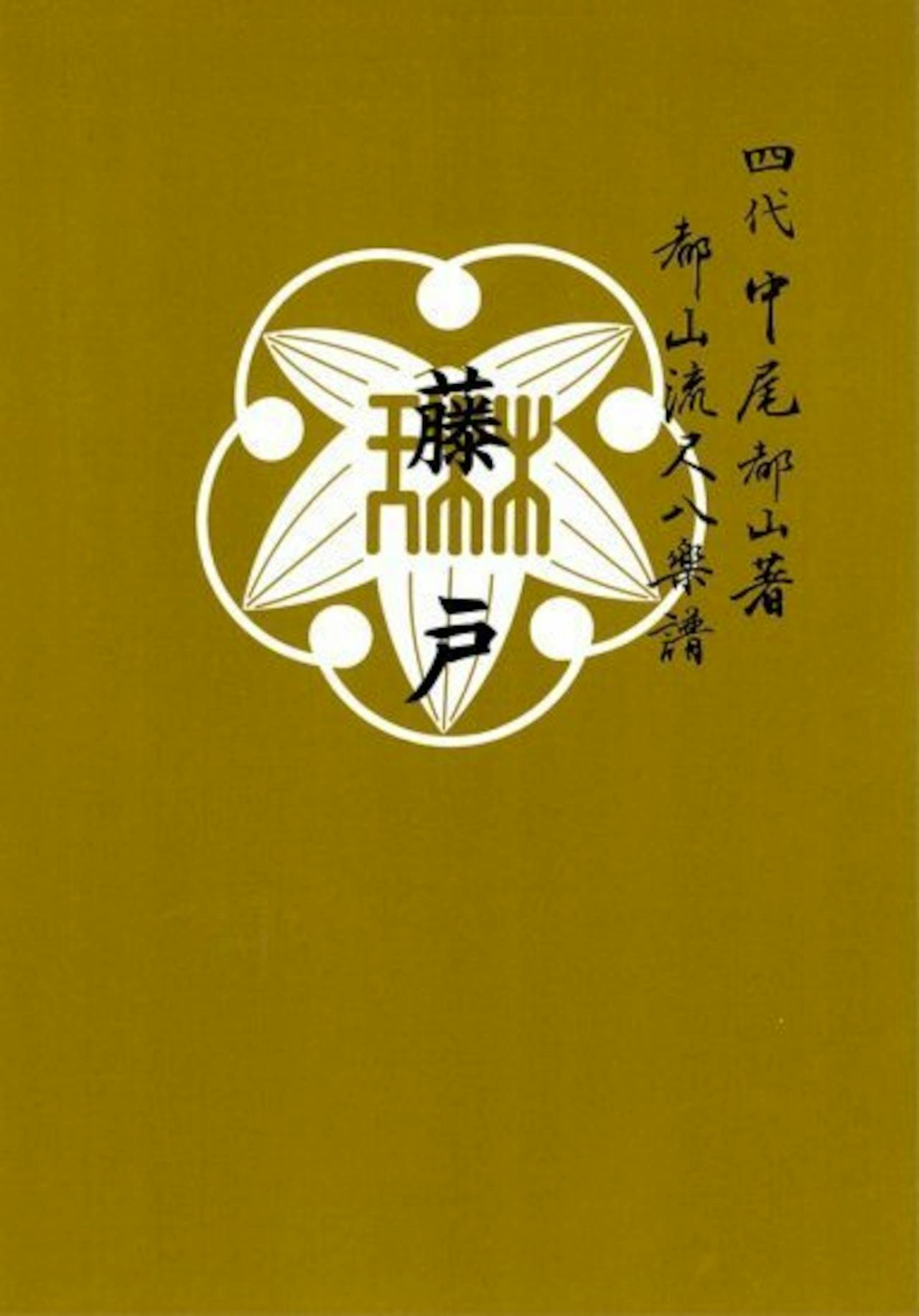 Book cover with a gold-brown background featuring a white stylized emblem and vertical Japanese text.