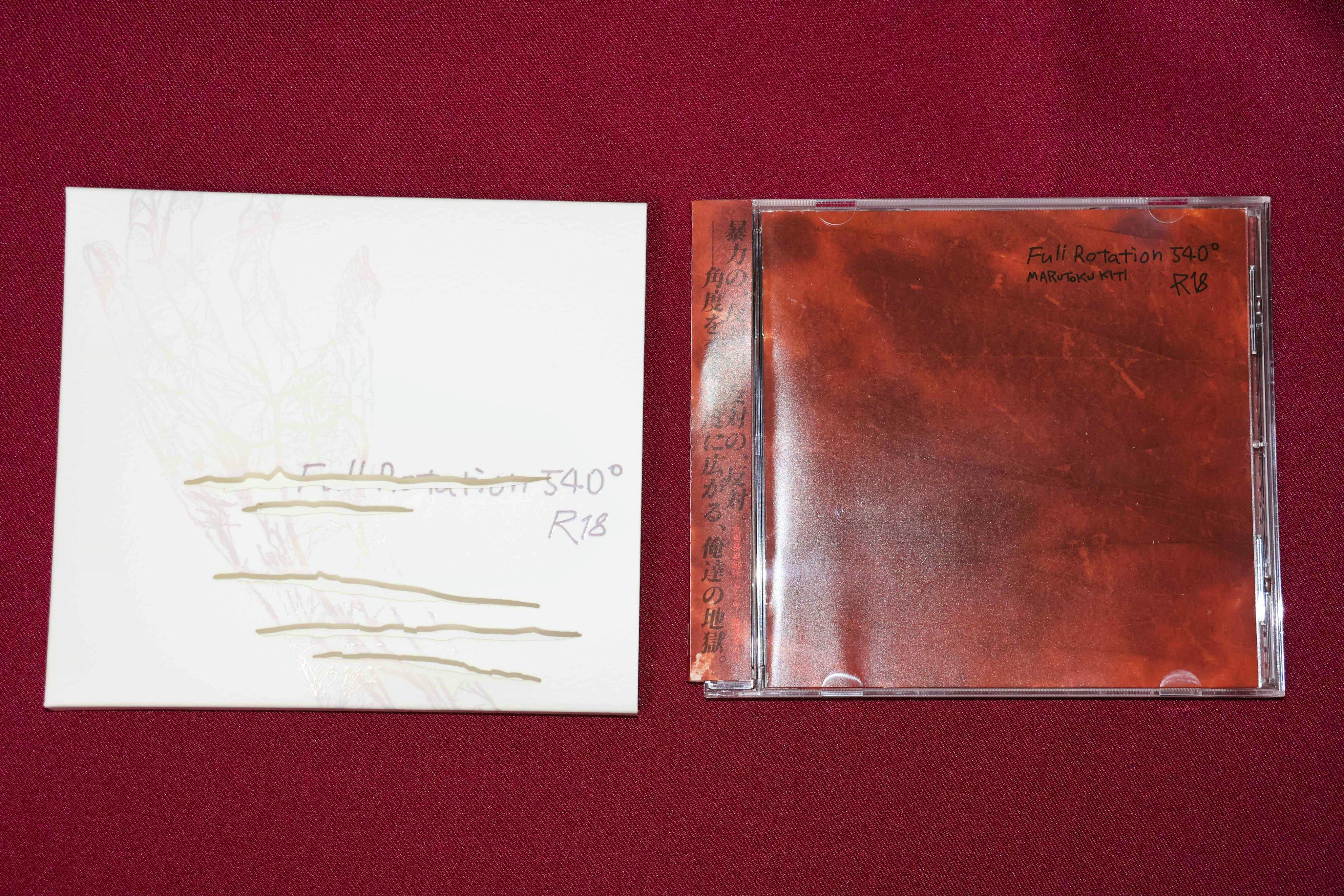 A jewel case and a white sleeve for the game disc Full Rotation 540° shown on a red fabric background.