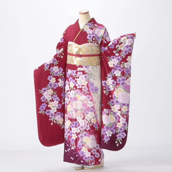 Mannequin wearing the red/wine floral furisode kimono with a gold obi on a white background.