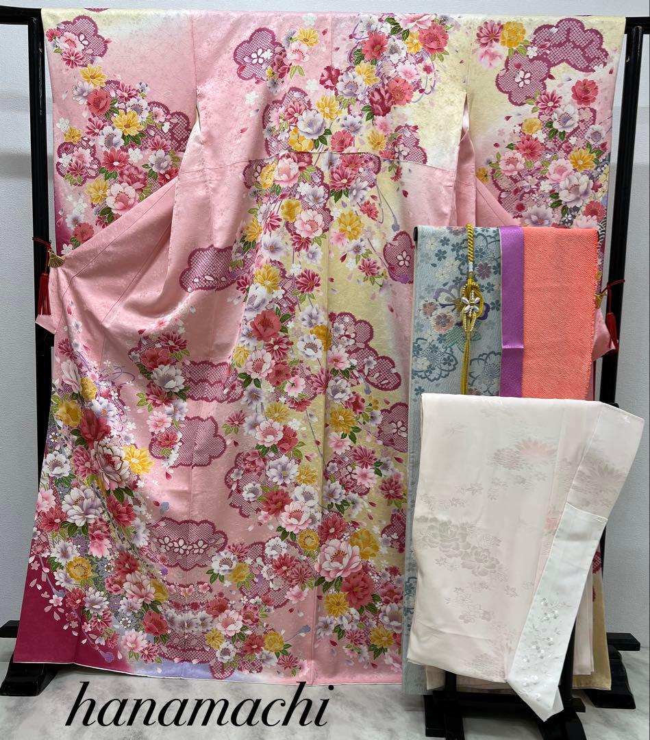 Pink floral furisode kimono with matching obi and a long juban displayed on a stand.