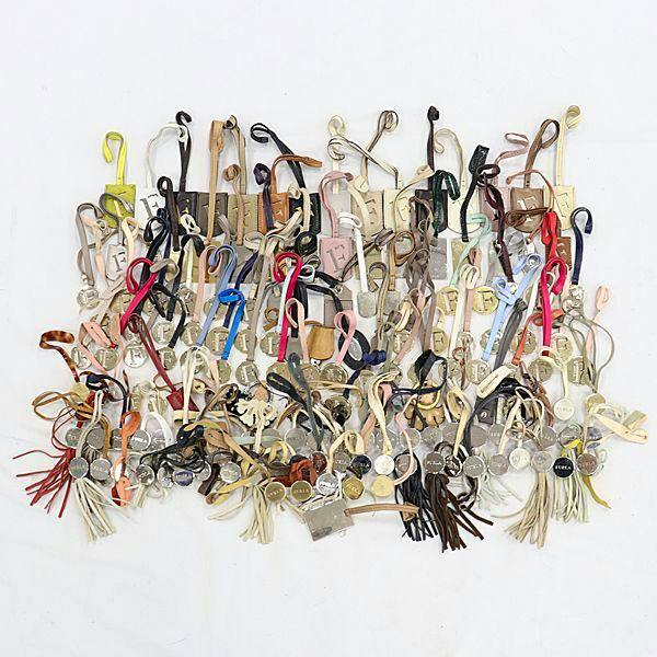 A spread of Furla charm keyrings and leather straps arranged on a white background.