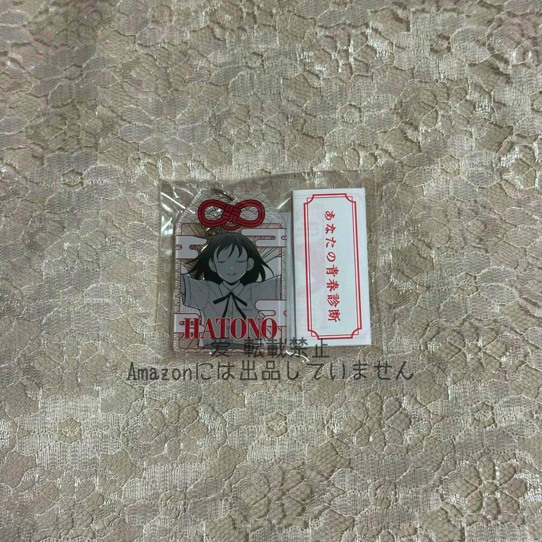 Packaged acrylic keychain featuring HATONO (鳩野ちひろ) next to a small paper omikuji on a lace background.