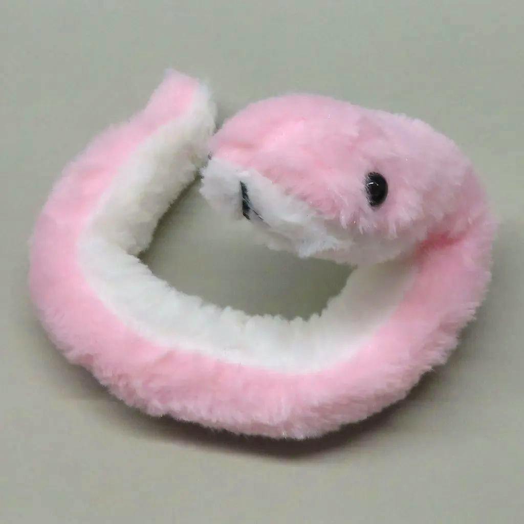 Pink and white fluffy snake plush mascot (plush badge) arranged in a circular shape on a neutral background.