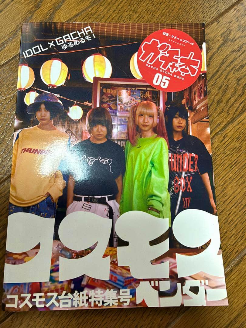 Front cover of ガチャ本05 showing four people standing beneath hanging paper lanterns.