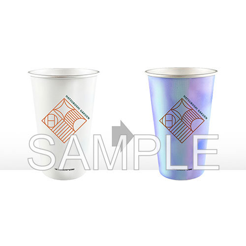 Two aluminum heat-sensitive cups side by side showing the unheated white state and the heated iridescent state, each with the printed HATSUBOSHI GAKUEN logo.