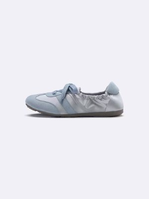 Side view of a light blue gathered ballet-style sneaker on a plain background.