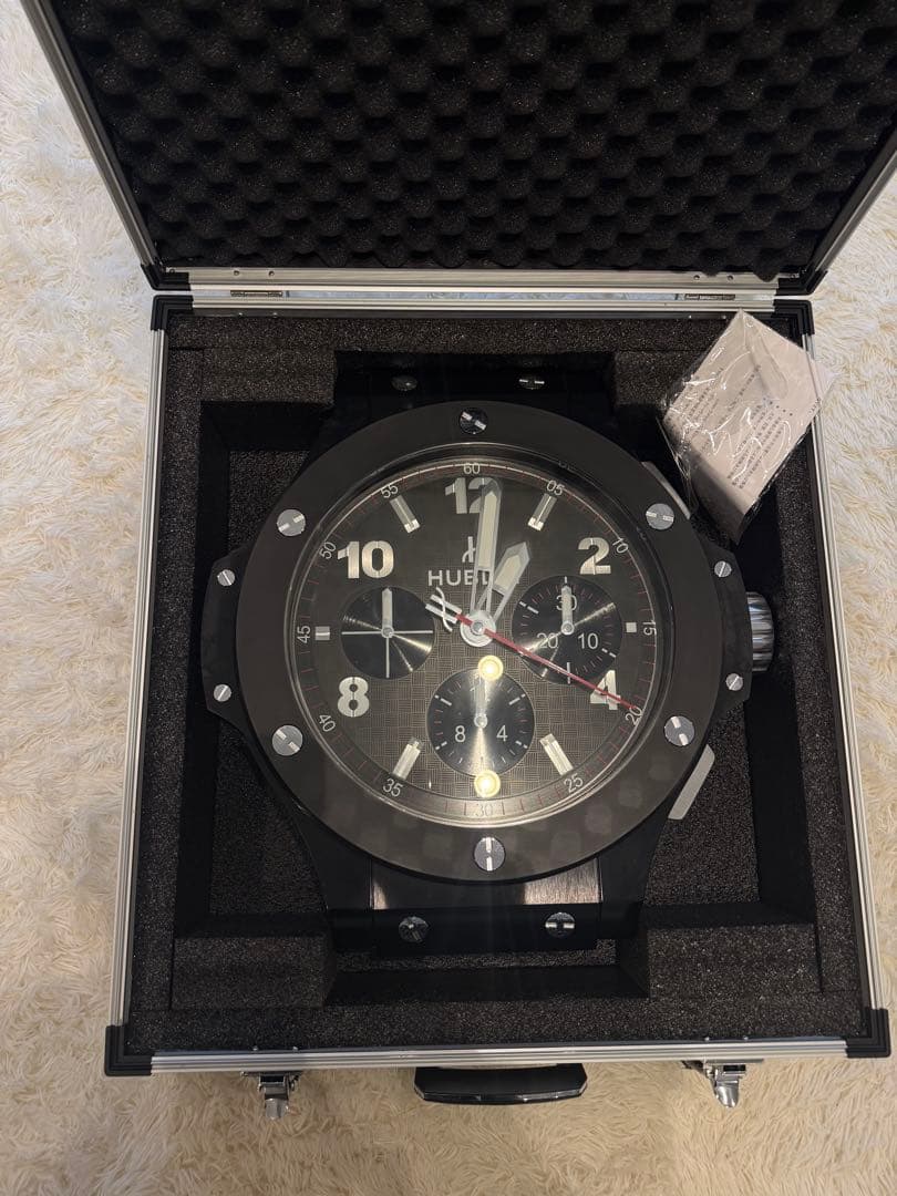 Top-down photo of the GENEVE HUBLOT Big Bang design wall clock showing the clock face inside a foam-lined aluminum carrying case.