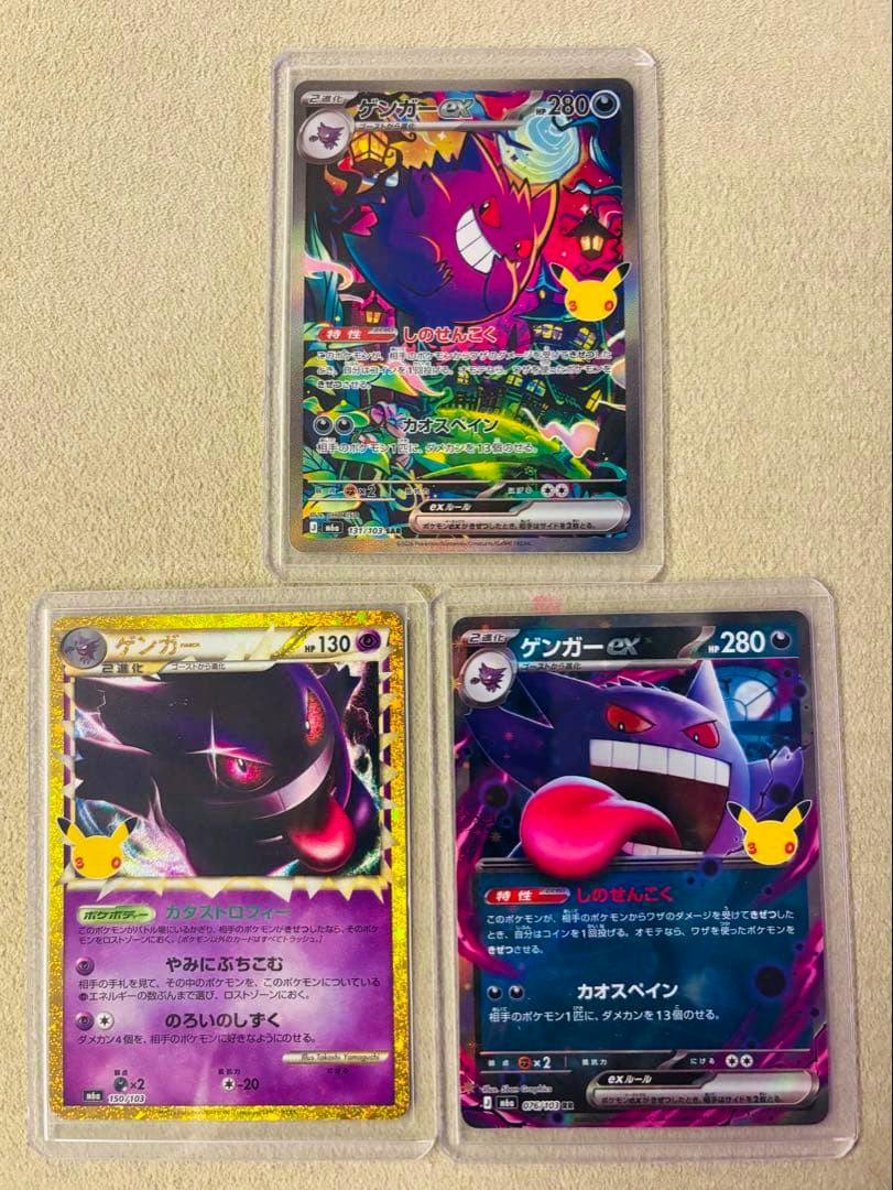 Three Gengar trading cards in clear sleeves arranged on a beige textured surface, showing front artwork.