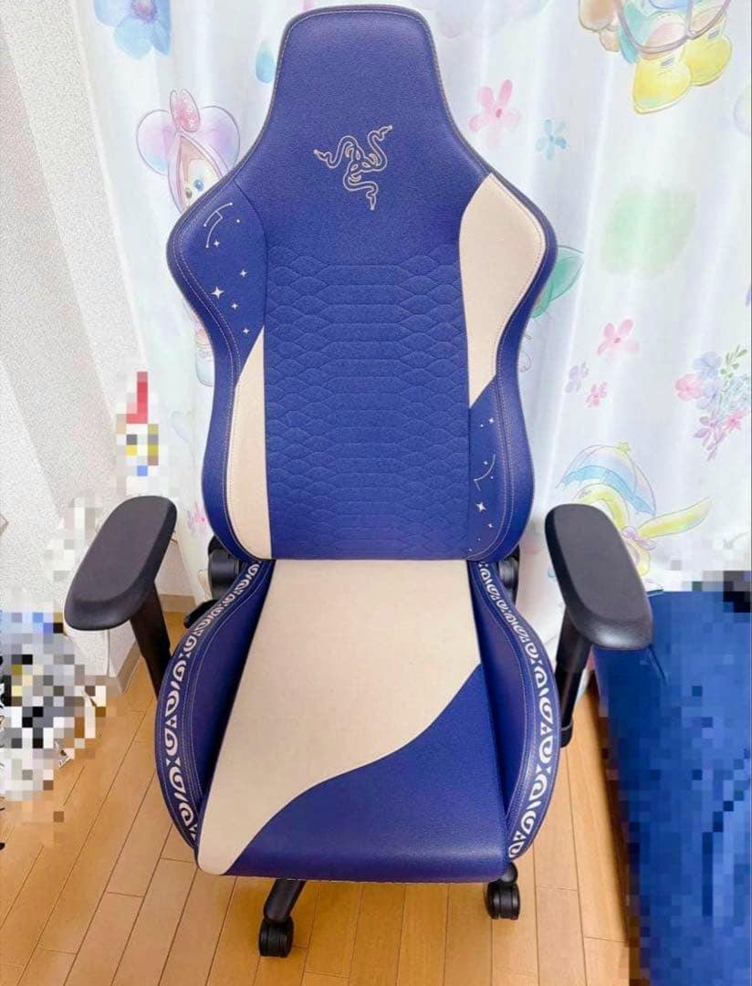 Front view of the blue and cream 原神 (Genshin) x Razer gaming chair showing the seat, backrest, adjustable armrests and caster wheels.