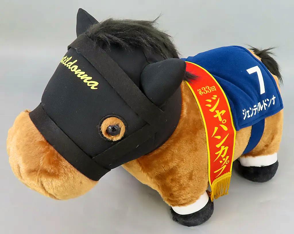 A plush horse toy wearing a black hood, a blue number 7 saddlecloth, and a red sash reading Japan Cup.