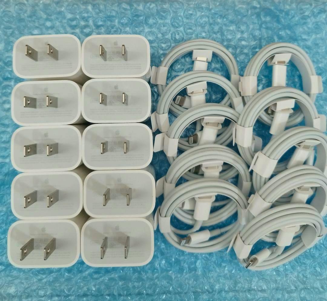 Ten Apple 20W USB-C power adapters and ten coiled USB cables arranged on blue bubble wrap.