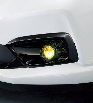 Close-up of a yellow LED fog light installed in a car's front bumper.