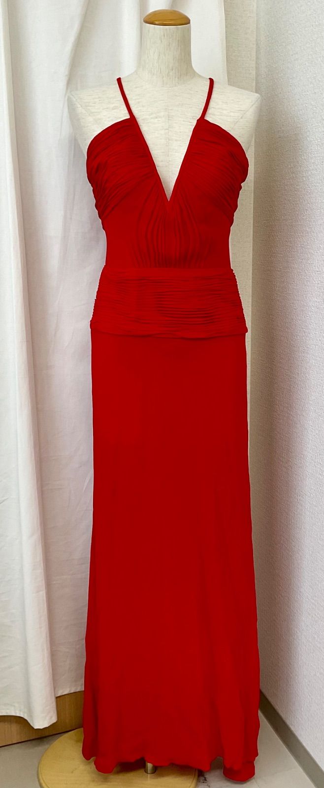 Red Gianni Versace long silk-blend dress displayed on a mannequin with thin shoulder straps and a deep V-neck.