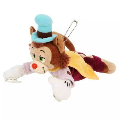 Plush 'Gideon' keychain shown lying face down with a blue hat, visible facial features, and an attached ball chain.