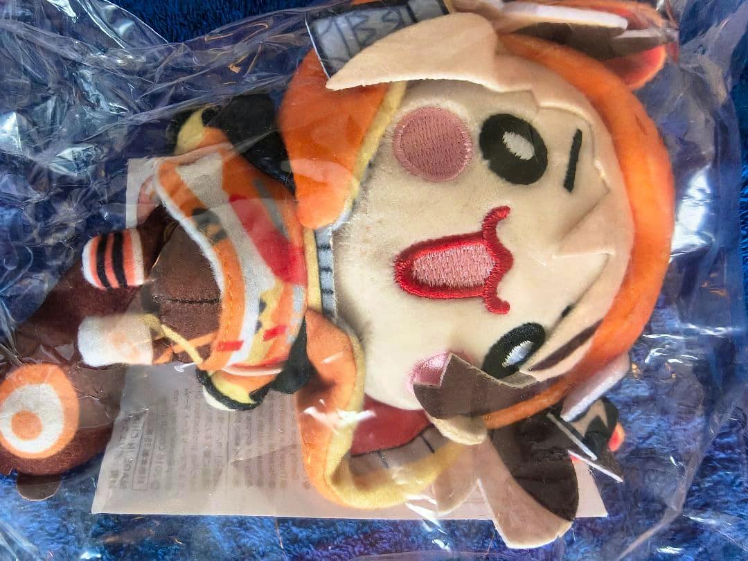 Photograph of the ジジ・ムリン Let'sGo Gigi plush keychain in its clear plastic packaging on a blue surface.