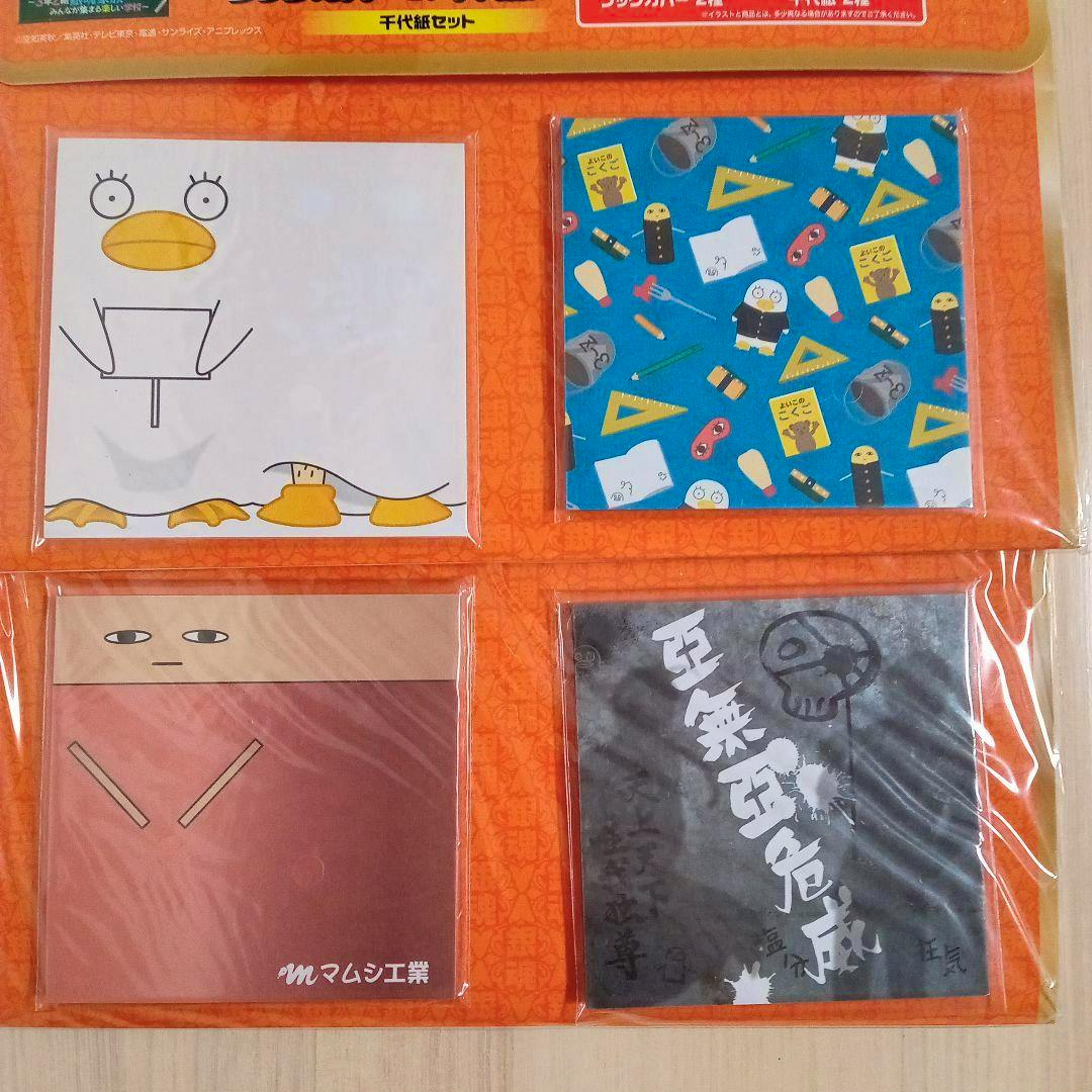 Four square memo pads with different printed character and pattern designs shown in orange packaging.