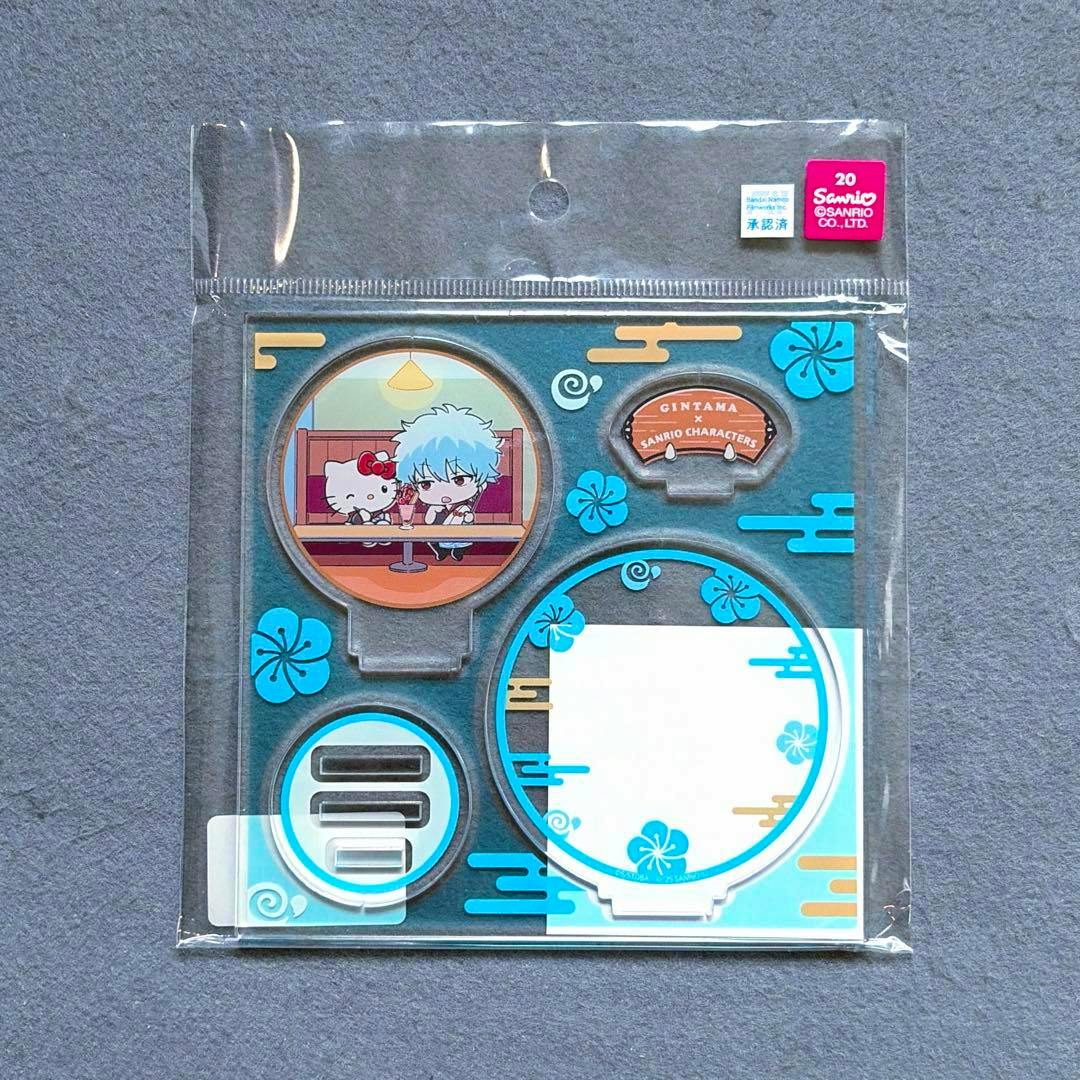 Packaged acrylic stand set showing a small illustration of Gintoki with a Sanrio character and the accompanying base pieces.