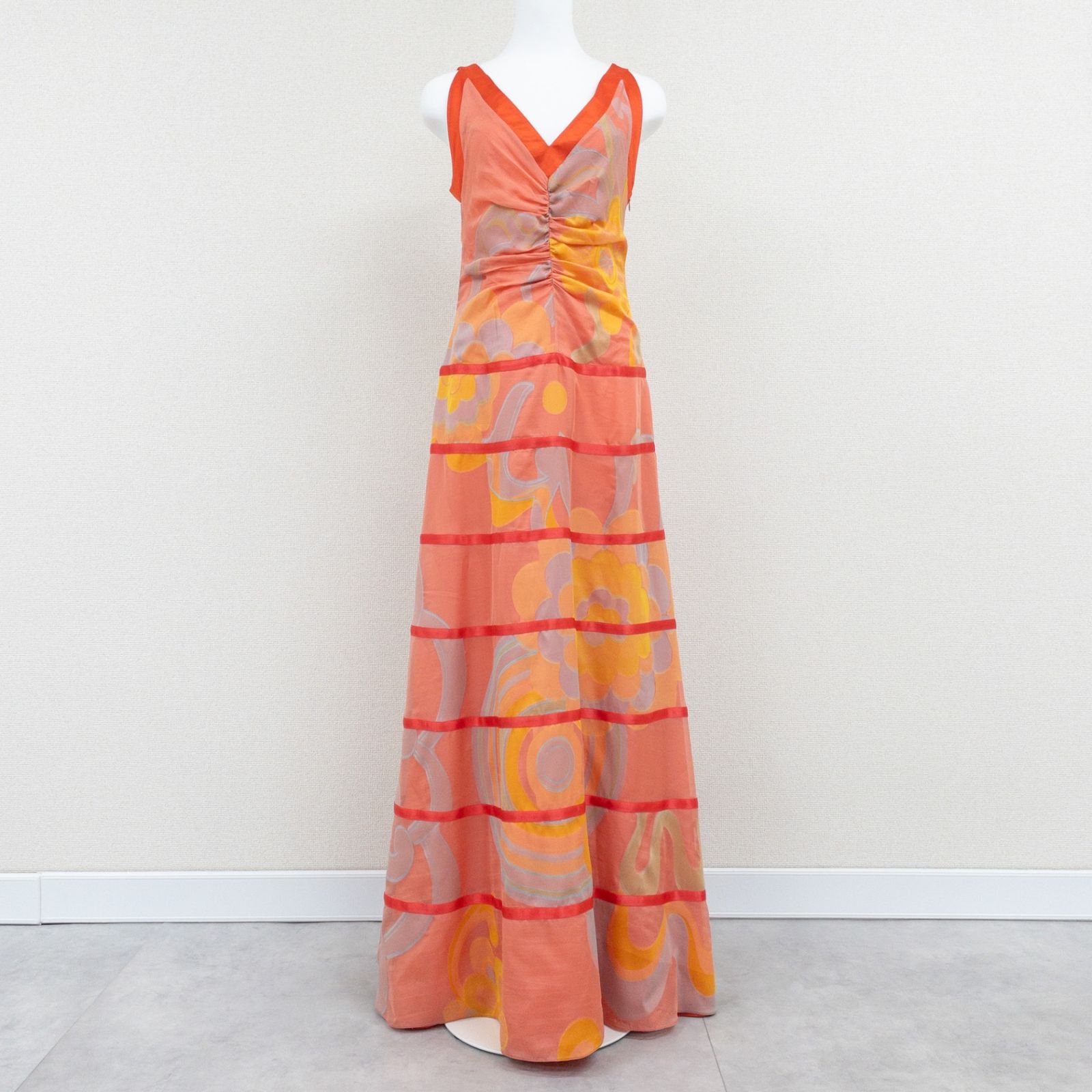 Orange patterned long Giorgio Armani women’s dress (polyester) displayed on a mannequin in full-length view.