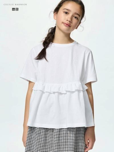 Front view of a girl wearing a white girls' frill cotton T-shirt with a ruffle across the chest.