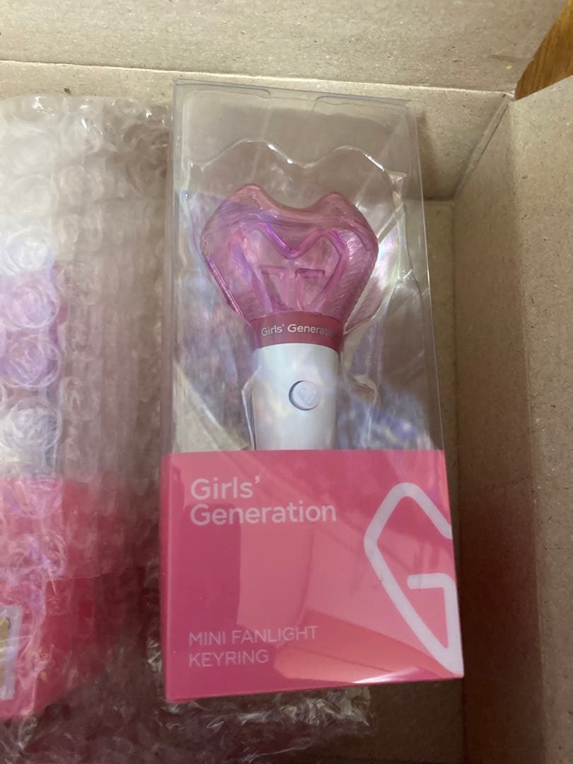Girls' Generation mini penlight keyring visible sealed in a clear plastic retail box with a pink label.