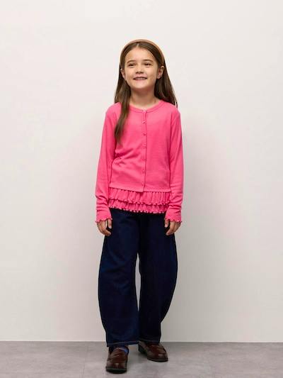 Young girl modeling a pink long-sleeve girls' cardigan with a ruffled hem, standing against a plain background.