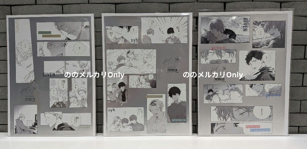 Three sticker sheets with black-and-white manga-panel designs from the Given exhibition, displayed upright against a gray tiled background.