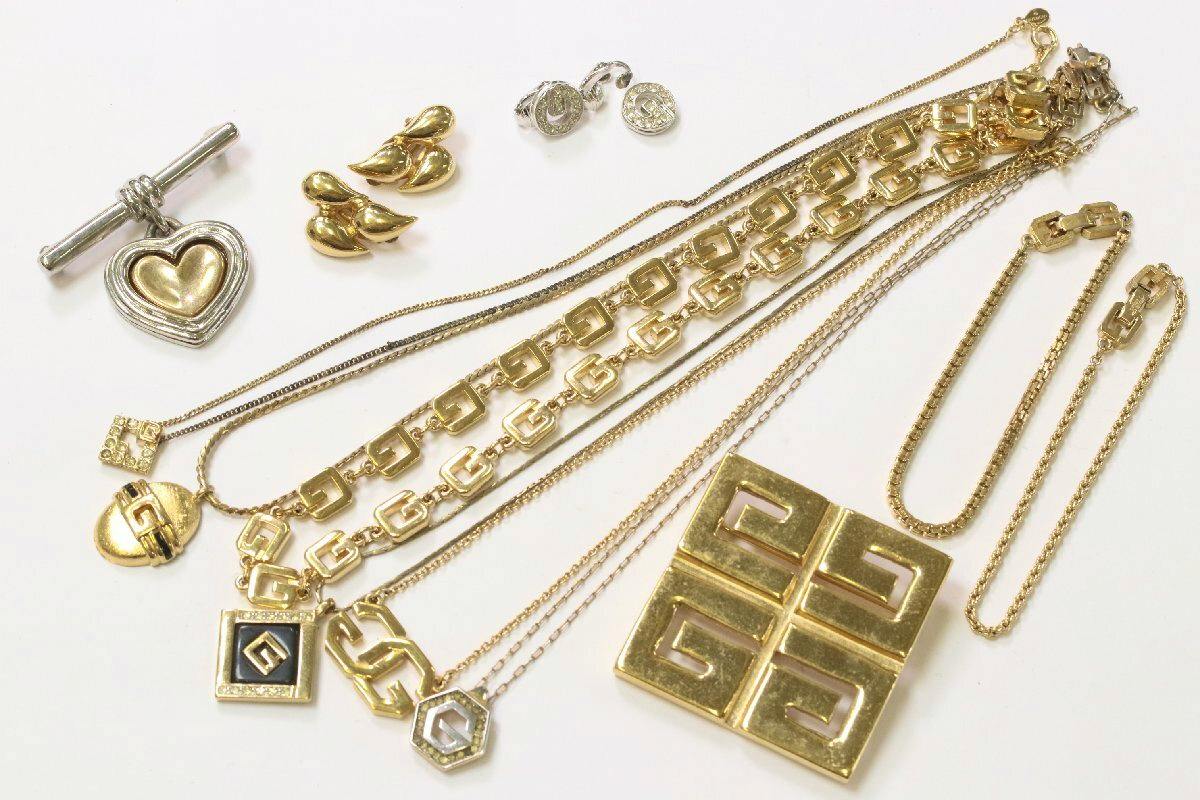 Multiple gold-tone Givenchy necklaces, pendants, bracelets, and earrings arranged on a white background.