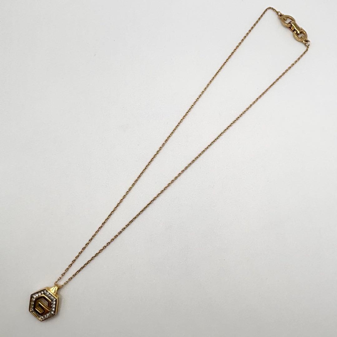 Full gold-tone GIVENCHY G-logo necklace with pendant and chain laid flat on a white background.
