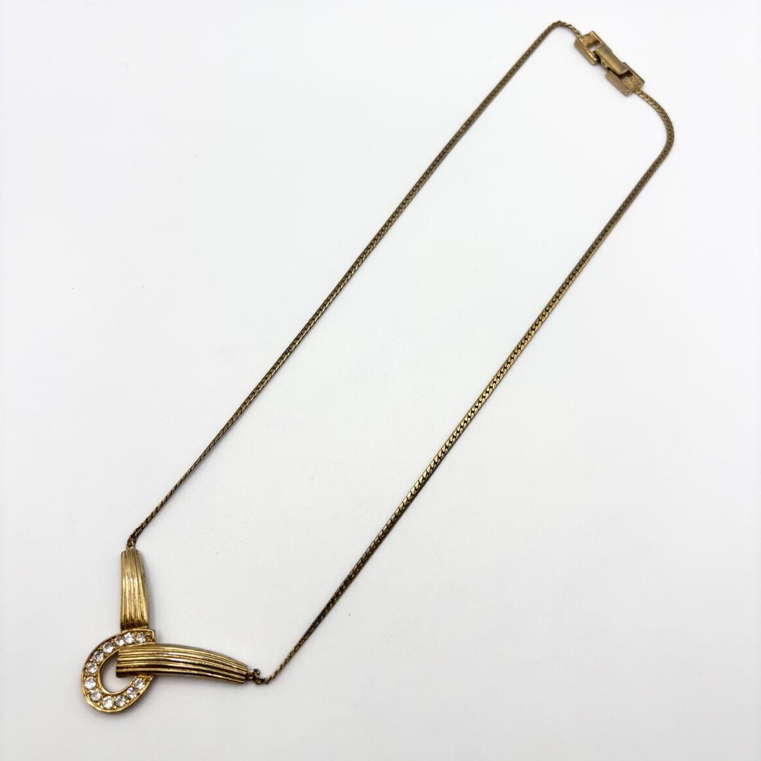 Gold-tone GIVENCHY rhinestone necklace laid flat on a white background showing the pendant, chain, and clasp.