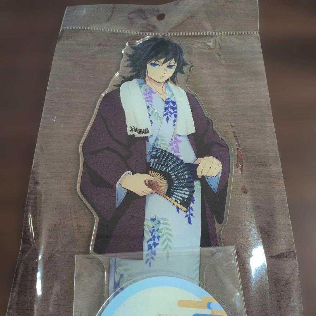 Packaged acrylic stand depicting 冨岡義勇 (onsen yukata version) visible inside clear plastic packaging.