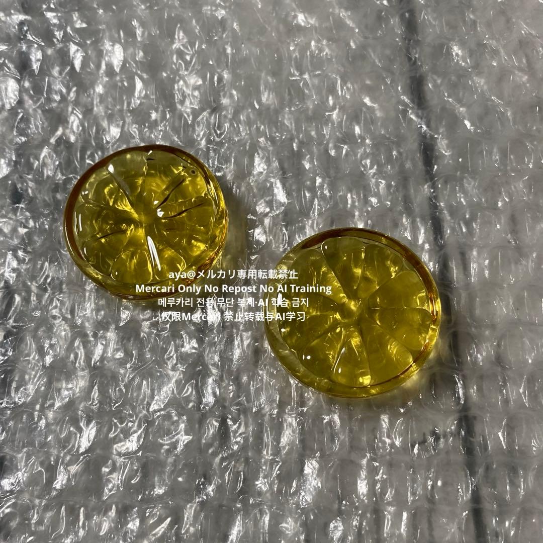 Two yellow glass lemon-slice chopstick rests placed on bubble wrap.