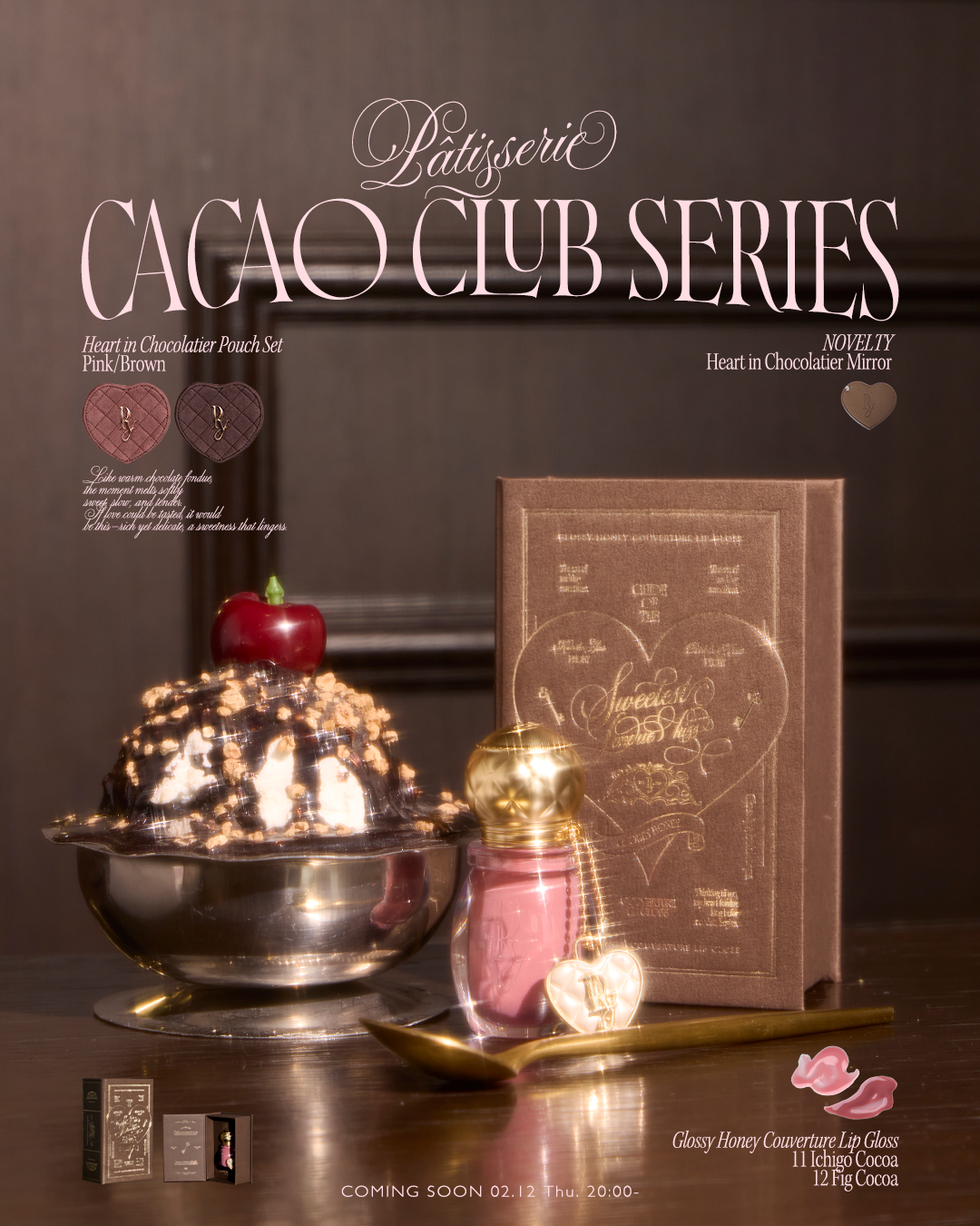 A glossy pink lip gloss bottle with a gold cap and heart charm displayed next to its brown box on a spoon in a dessert-themed setting.