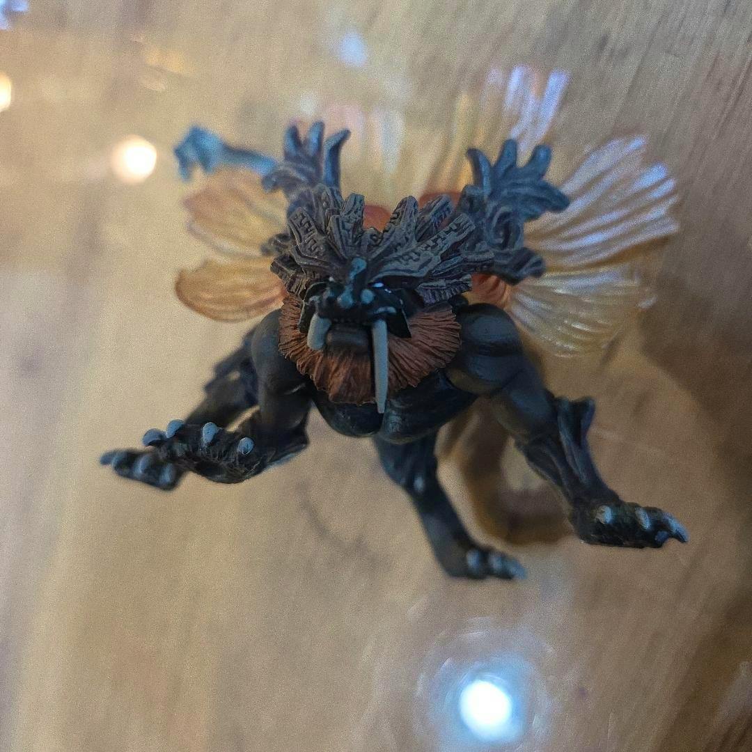 Plastic figure of the GOD EATER "Vajra" creature shown from above on a wooden surface.