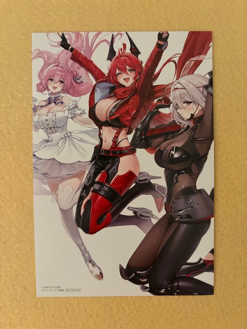 Front of the postcard showing printed anime artwork of three characters from Goddess of Victory: NIKKE.