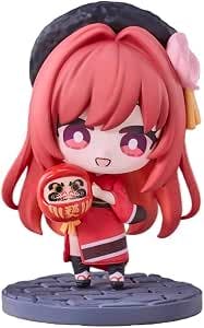 SD-form Goddess of Victory: Nikke figure in New Year outfit standing on a round base and holding a small red daruma.