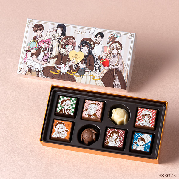 Open Godiva × CLAMP assortment box of eight chocolates, with the chocolates displayed and the illustrated outer box visible.